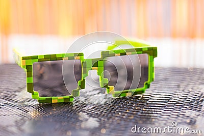 Green pixel sunglasses with black lenses closeup in a sunny day. Selective focus Stock Photo