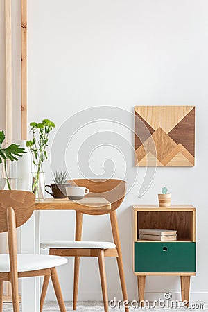 Plants in small vases on long wooden dining table in bright interior Stock Photo