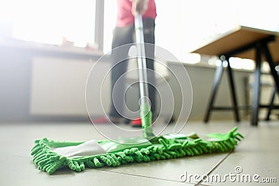 Green plastic mop cleaning laminated light dirty floor Stock Photo