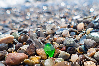 Green polished glass pebble on seashore Stock Photo