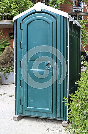 Green portable toilet or Porta Potty on a construction site Stock Photo