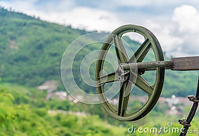 Green Pulley Wheel on the Shaft with Blur Mountain Stock Photo