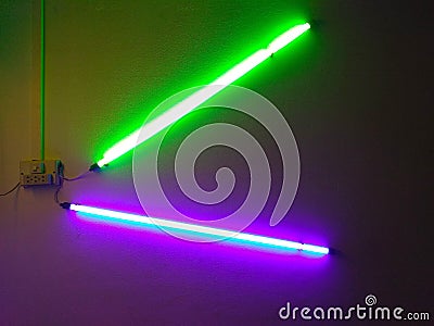 Green and purple light bulbs give light to the room Stock Photo