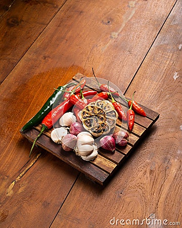 Green and red chili, garlic, and onion on wooden placemats Stock Photo