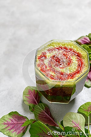 Green and Red drink made from berries and spinach leaves on bright background. Superfoods, healthy lifestyle concept. Vegetarian f Stock Photo