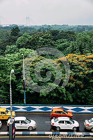 Green and red leaf trees in the park and cars on the road from above with Vidyasagar Setu. Editorial Stock Photo