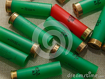 Green and red shell cartridge shotgun lie down on brown surface Stock Photo