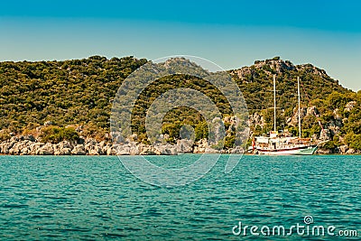 Green rocky coast in mediterranean sea with stones in turquoise sea water. Stock Photo