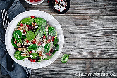 Green salad spinach bowl with quinoa, pomegranate, walnuts, feta cheese and dried cranberries. Stock Photo