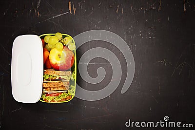Green school lunch box with sandwich, apple, grape and carrot Stock Photo