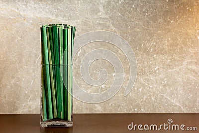 Green sedge leaf in jar on the wood table and marble wall Stock Photo