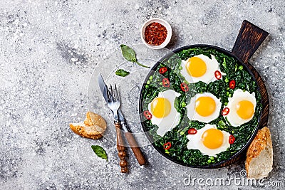 Green shakshuka with spinach, kale and peas. Healthy delicious breakfast. Top view, overhead, flat lay. Stock Photo