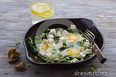 Green shakshuka with spinach, leek and feta in a ceramic frying pan Stock Photo