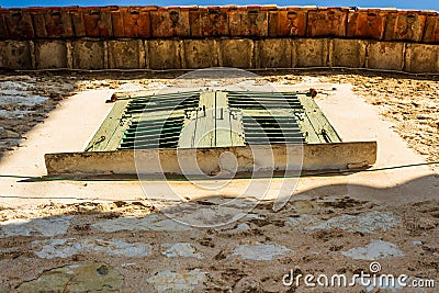 Green shuttered windows against a weathered brown wall in Eze, France Stock Photo