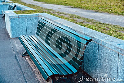 Green sitting empty wooden bench around a park in Berlin Stock Photo