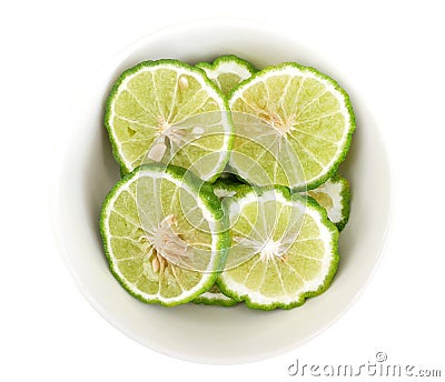 Green sliced bergamot kaffir lime balls herb in ceramic bowl isolated on white background, clipping path Stock Photo