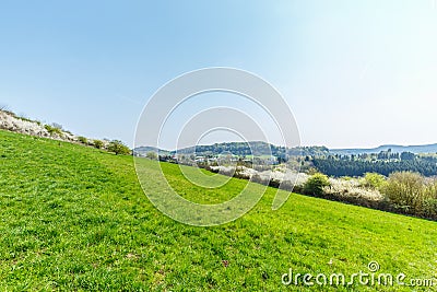 Green slopes in spring landscape in the German Eifel region near to Gerolstein, Germany Stock Photo