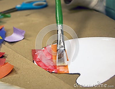 Green small paint brush doing decopouche with tissue paper Stock Photo