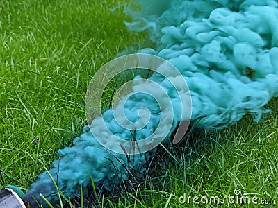 Green smoke from a smoke grenade pouring out over grass Stock Photo