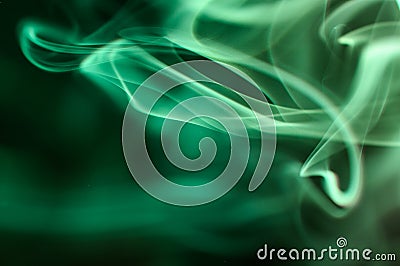 Green smoke swirling against a dark background Stock Photo