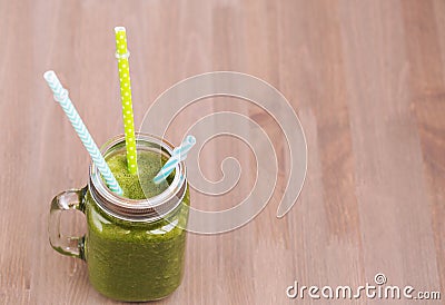 A green smoothie in a mason jar with thre tubes Stock Photo