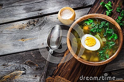 Green soup with sorrel in wooden bowl. Stock Photo