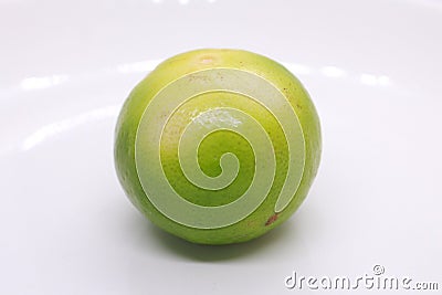 one green sour lime on a plate Stock Photo