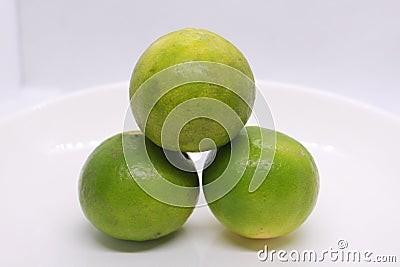 three green sour lime on a plate Stock Photo