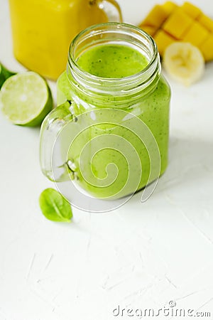 Green Spinach Avocado Smoothie and Banana Mango Smoothie in mason jars Stock Photo