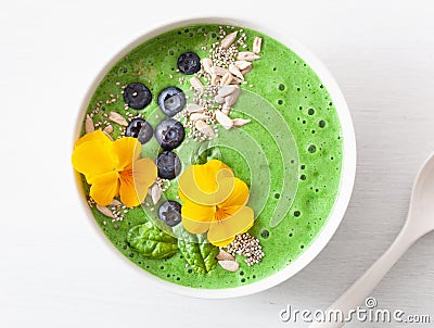 Green spinach smoothie bowl with blueberry, chia seed and edible Stock Photo