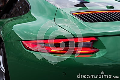 Green sports car with red backlight on. Closeup. Editorial Stock Photo