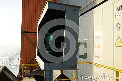 Green starboard side navigational lights of the loaded container ship in metal box . Editorial Stock Photo