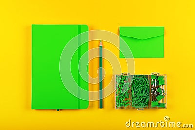 Green stationery flat lay over yellow Stock Photo