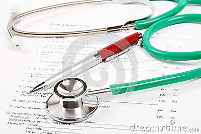 Green stethoscope and a red pen lying on a medical history form Stock Photo