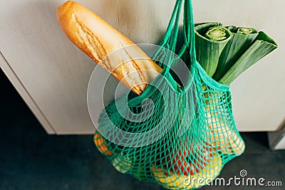 Green string shopping bag hanging on a hook in the kitchen Stock Photo