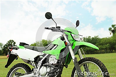 Green stylish cross motorcycle on grass outdoors Stock Photo
