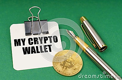 On a green surface, a bitcoin coin, a pen and a sheet of paper with the inscription - My crypto wallet Stock Photo