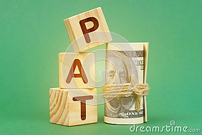 On a green surface, dollars and cubes with the inscription - PAT Stock Photo