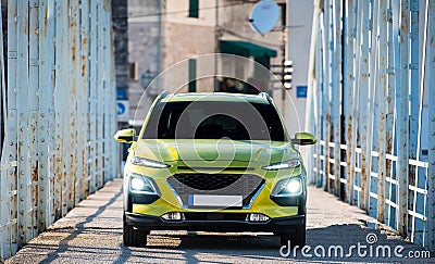 Green SUV car with lights on standing on metal bridge Stock Photo