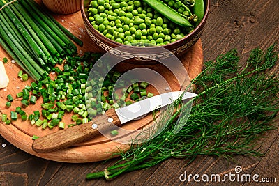 Green sweet peas on a dark wooden background, onion, still life, concept of fresh and healthy food Stock Photo