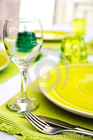 Green tableware and cutlery and white tablecloth set at an outdo Stock Photo