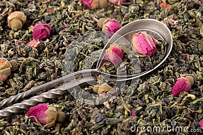 Green tea leaves with rose buds Stock Photo