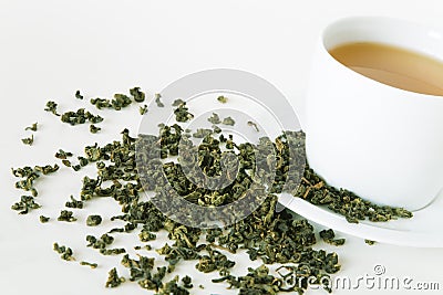 Green tea leaves and white cup Stock Photo