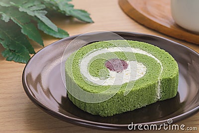 Green tea roll cake with red bean on plate Stock Photo