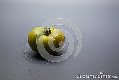 Green tomato on plain background, healthy food Stock Photo