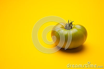 Green tomato on plain background, healthy food Stock Photo