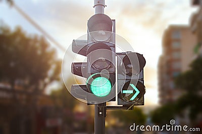 Green traffic light with green arrow light up in city while sunset allows car to turn right Stock Photo