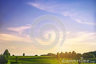 Green trees, field and sunset sunrise sky with fluffy cirrus clouds soft focus in summer. Heavenly clouds background. Stock Photo