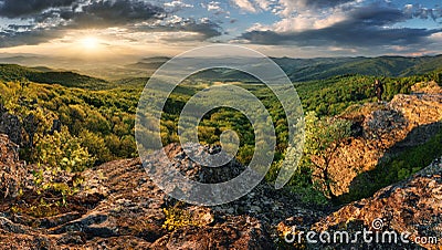Green trees on mountain under dramatic spring sunset Stock Photo