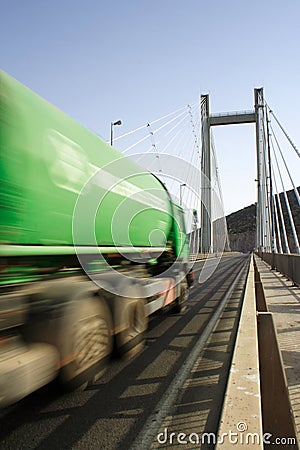 Green Truck In Motion on a cable-stayed bridge Stock Photo